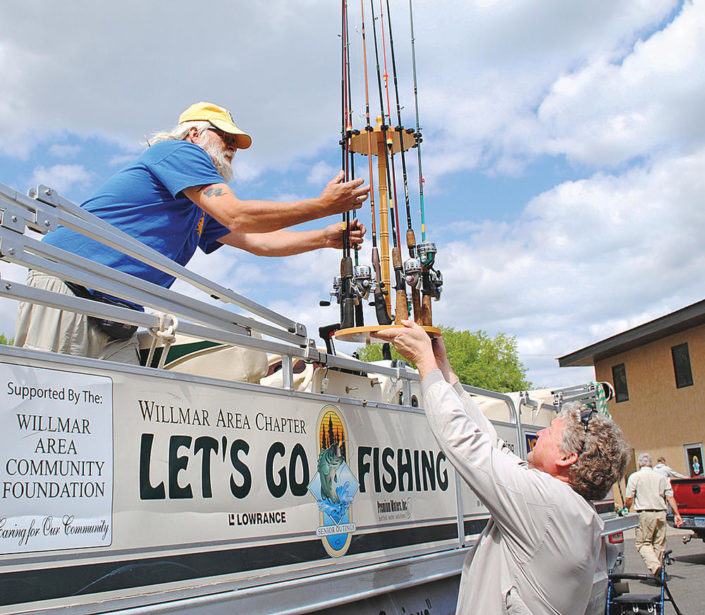 Let’s Go Fishing is launching its 2016 season on Monday. Joe Holm, director, lifts fishing rods and reels to Kevin Rache, a volunteer with the Willmar chapter, as they equip a pontoon boat for the season ahead. They were busy outfitting the pontoons at th